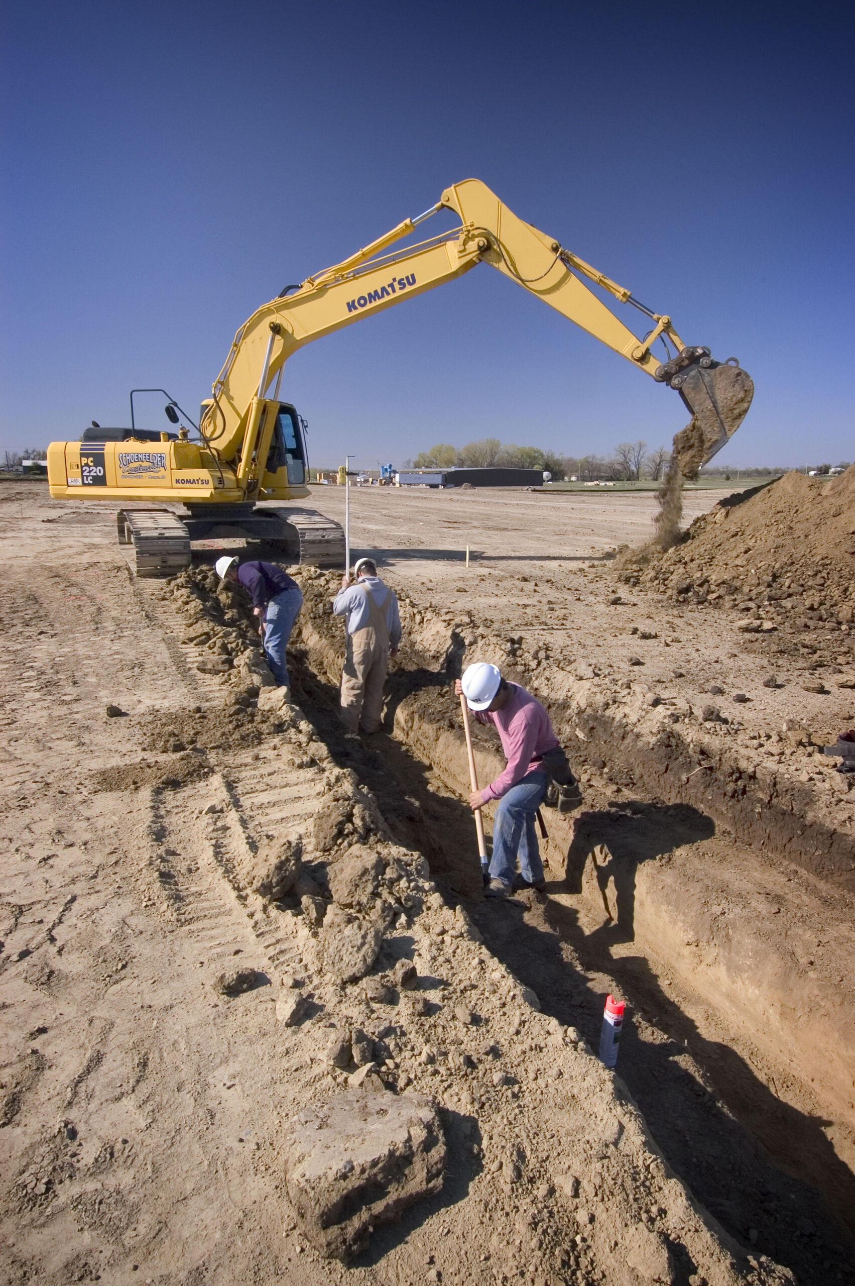 Backhoe and line of people digging.