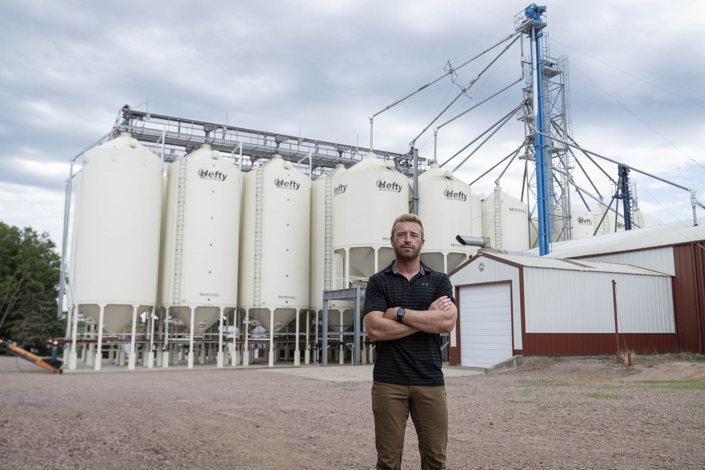 Man standing in front of farm facilities.