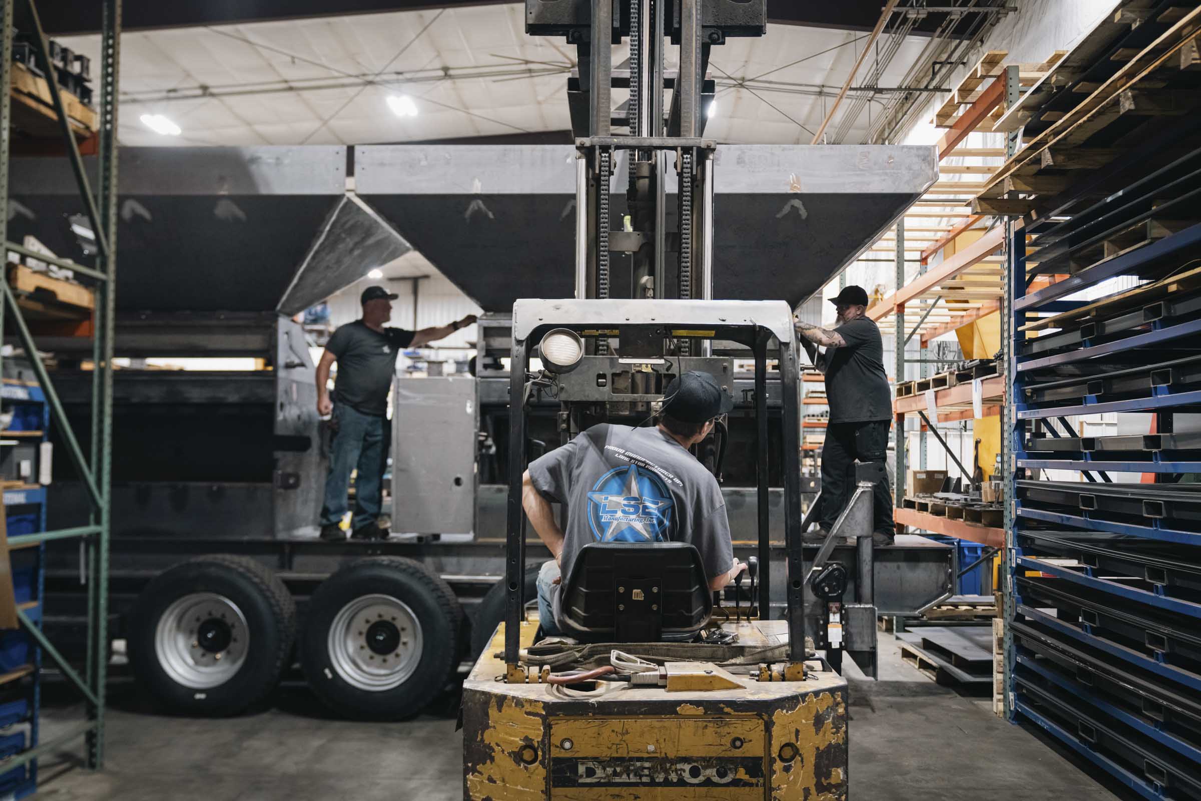 Man operating forklift in manufacturing facility.