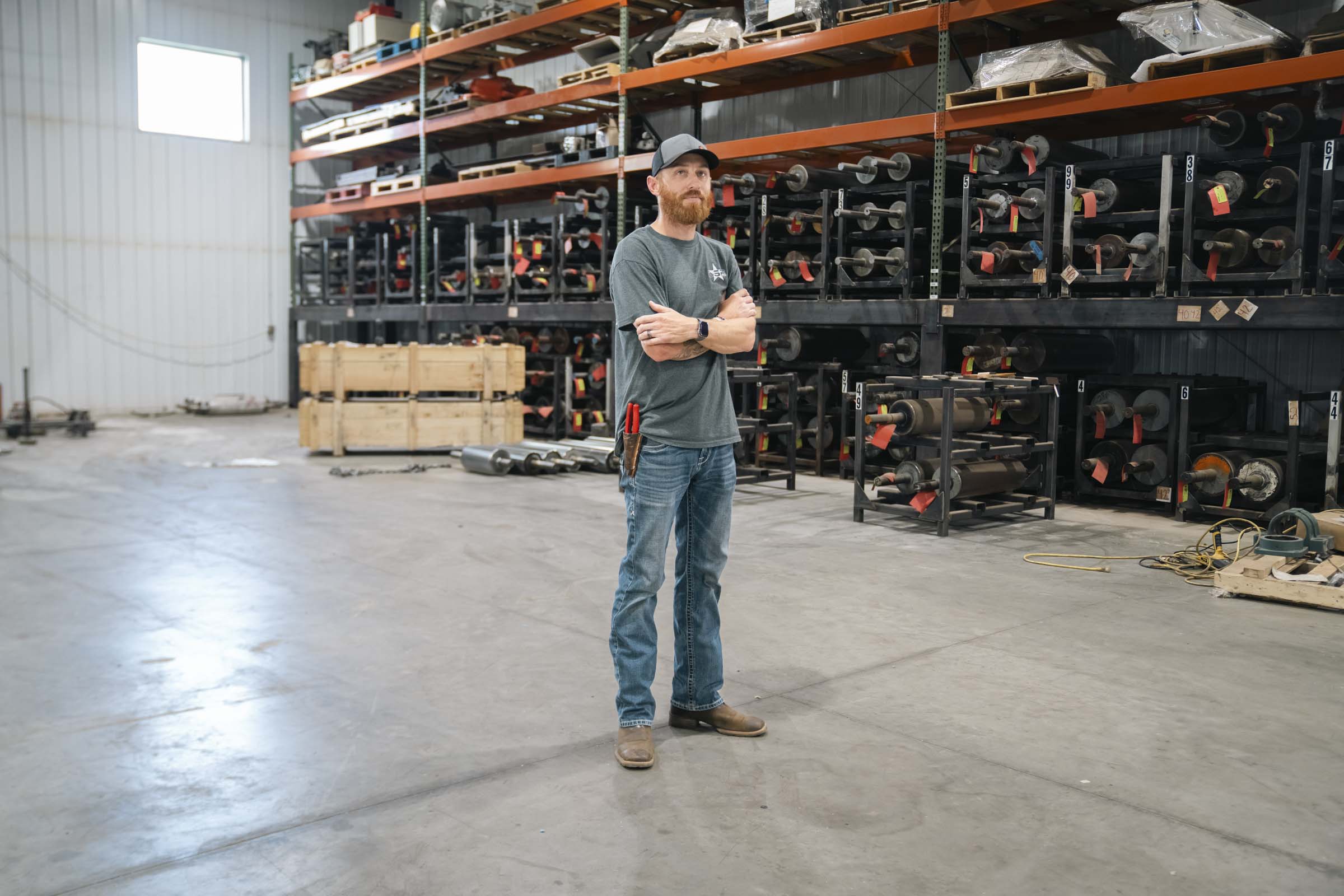 Man standing inside manufacturing warehouse.