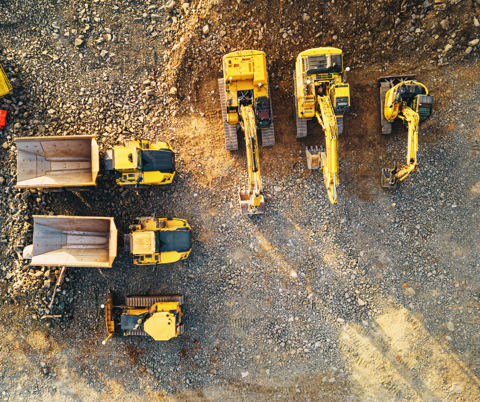 Construction vehicles in dirt field.
