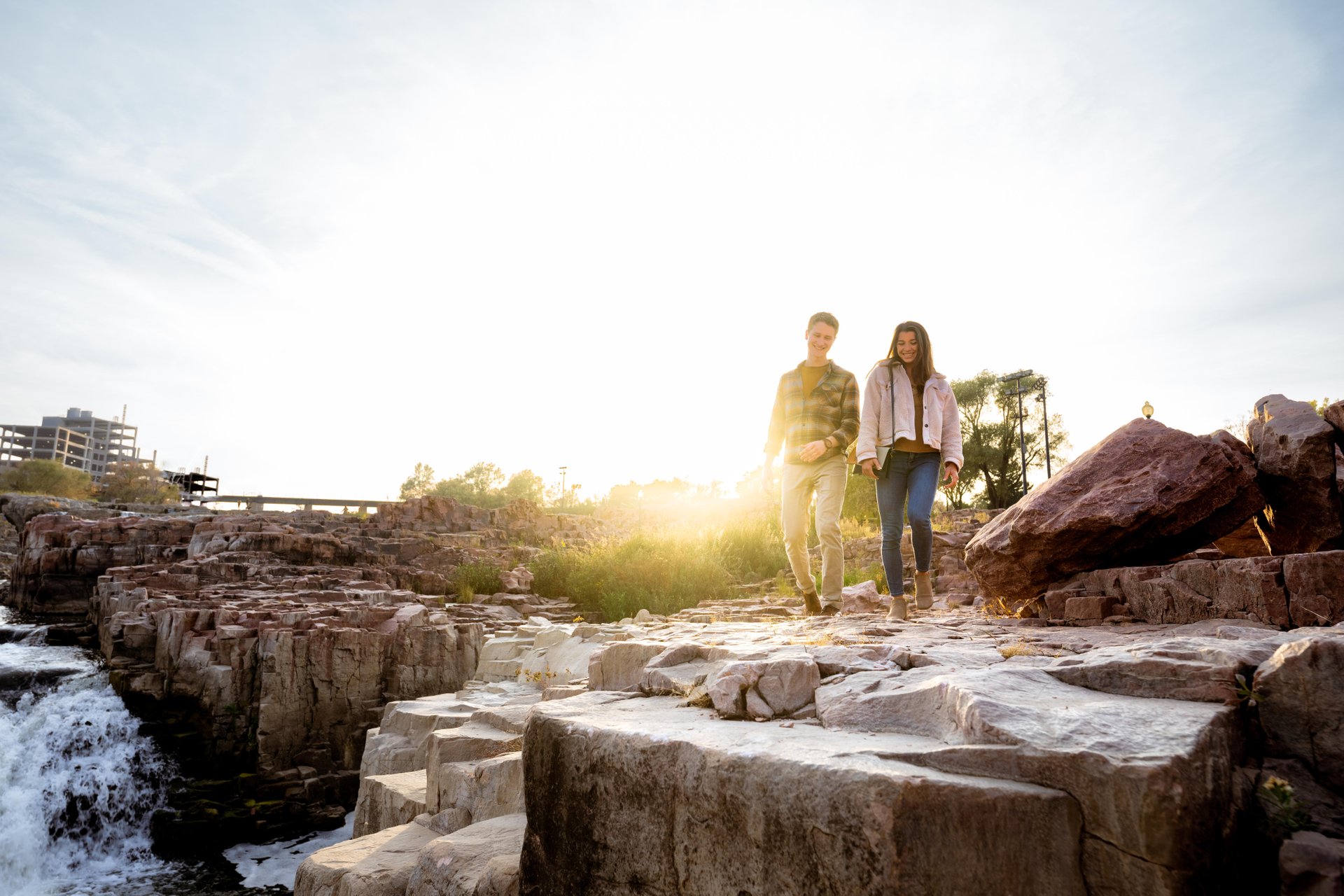 Couple standing on top of rock at sunset at Falls Park in South Dakota